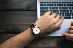 watch on hand over laptop keyboard