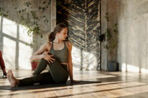 Girl on the floor with leg crossed over the other, practicing her flexibility