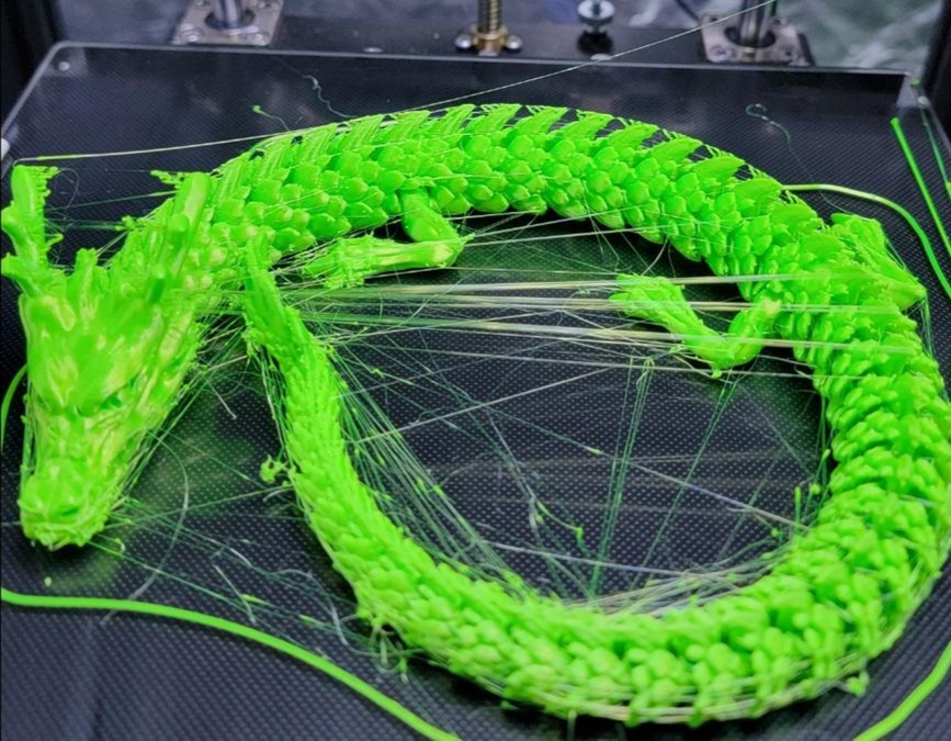 Filament strings on a 3D printed dragon