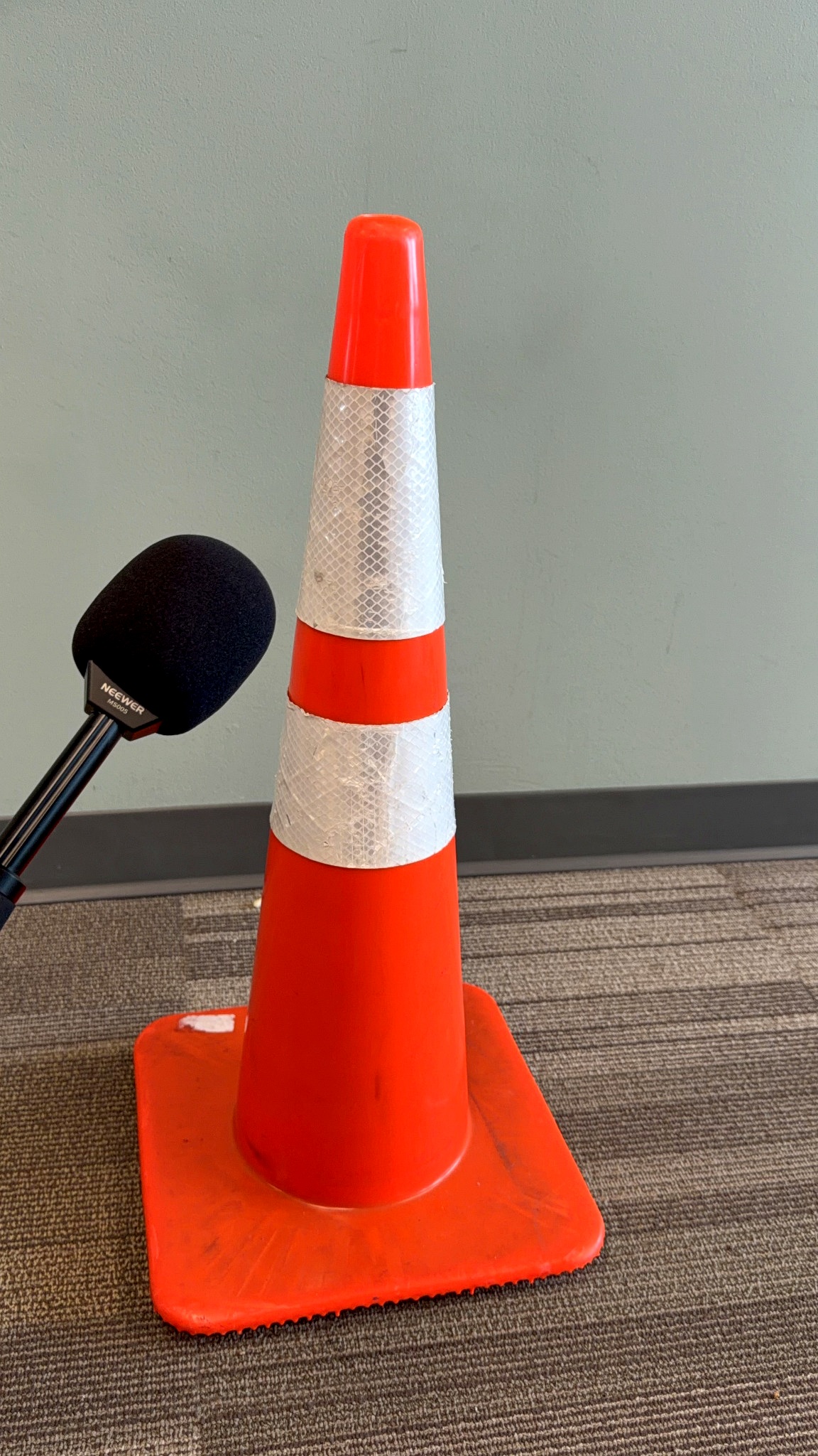 A microphone held toward a traffic cone